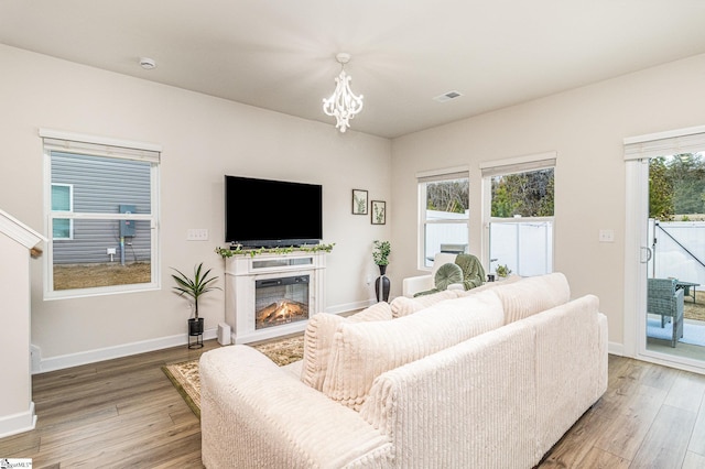 107 Tramore Ln, Fountain Inn, SC 29644 - living room with baseboards, light wood-style flooring, and a notable chandelier