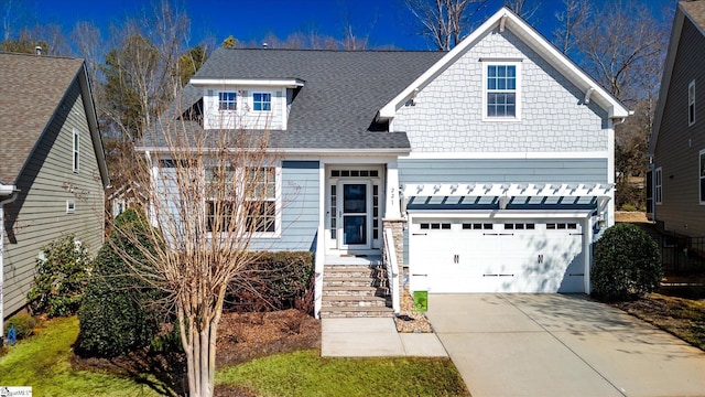 view of front of house with concrete driveway, roof with shingles, and an attached garage