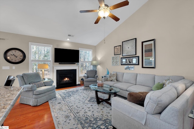 living area with plenty of natural light, a fireplace with flush hearth, visible vents, and light wood-style floors