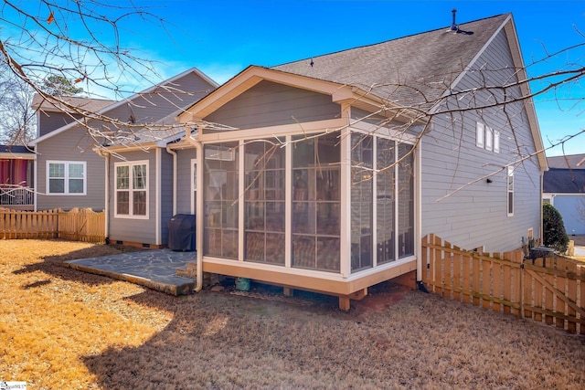 back of property with a patio, a shingled roof, a sunroom, crawl space, and a fenced backyard