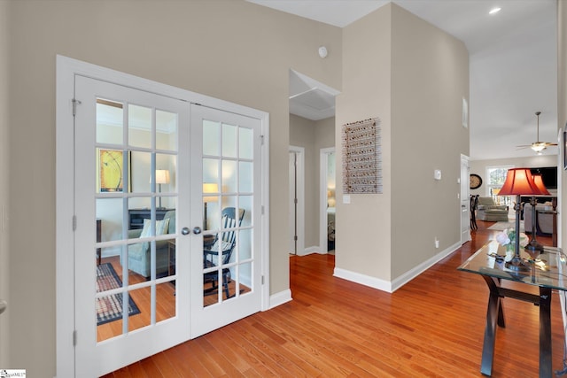 doorway featuring french doors, wood finished floors, a ceiling fan, and baseboards