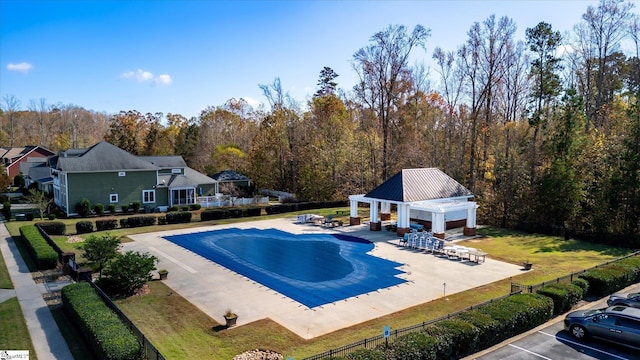 view of pool featuring a gazebo, a wooded view, a patio area, and fence