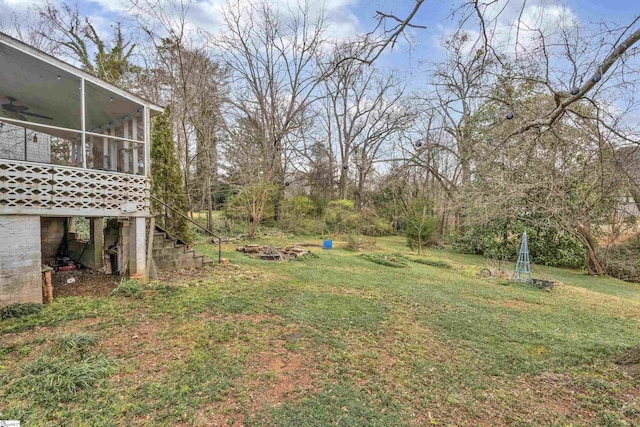 view of yard with a sunroom, stairway, and a ceiling fan