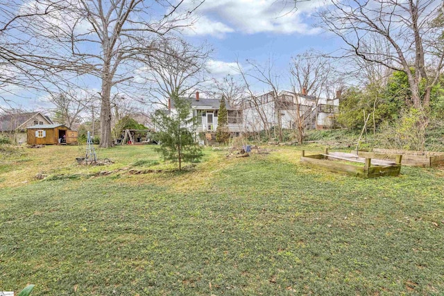 view of yard featuring a vegetable garden and an outbuilding