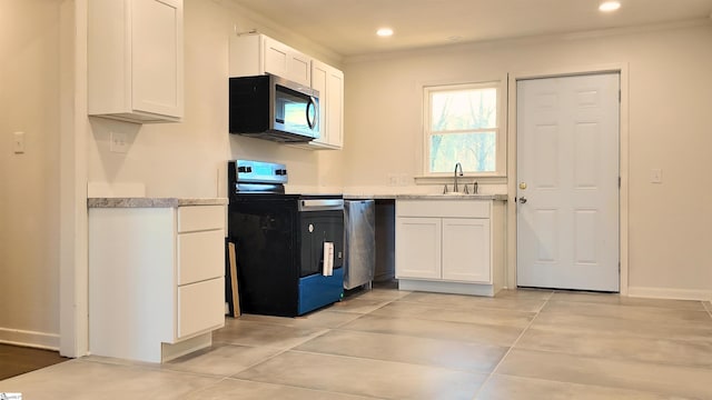 kitchen featuring stainless steel appliances, recessed lighting, light countertops, white cabinetry, and a sink