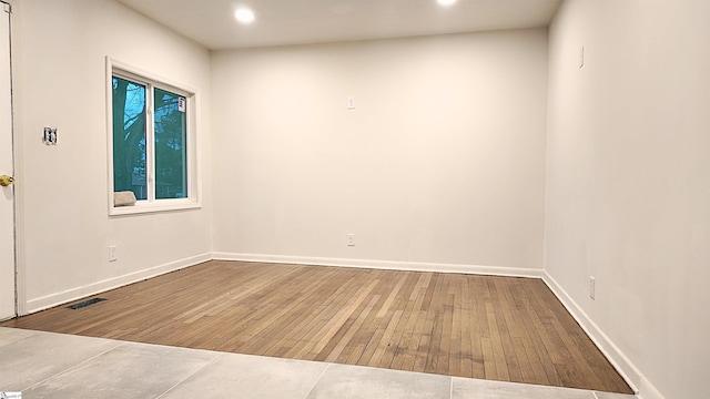 spare room with recessed lighting, visible vents, baseboards, and hardwood / wood-style flooring