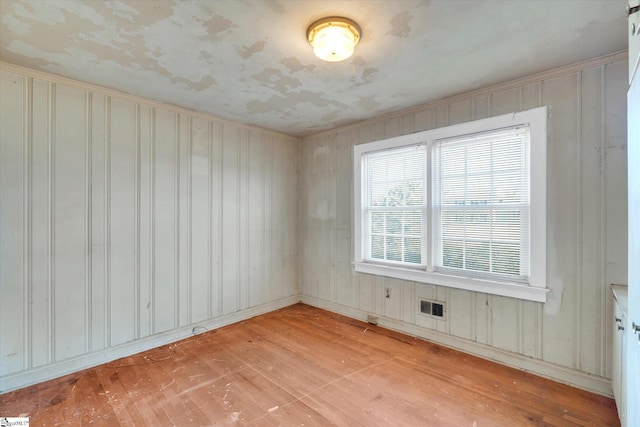 spare room with light wood-style flooring and visible vents