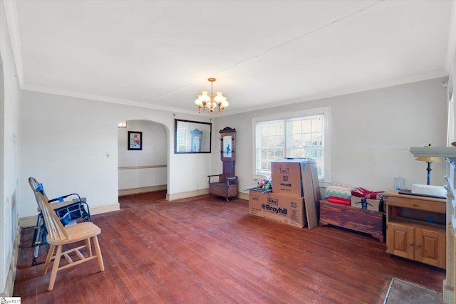 living area with baseboards, crown molding, arched walkways, and wood finished floors