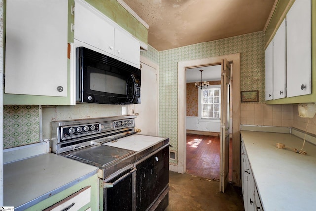 kitchen with wallpapered walls, black microwave, stove, light countertops, and white cabinetry