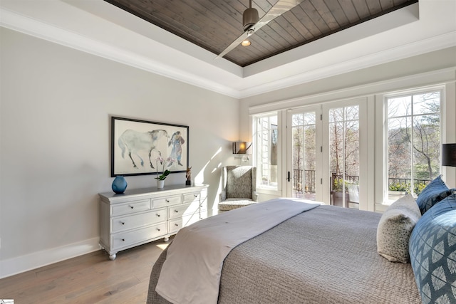 bedroom with wood ceiling, access to outside, multiple windows, and a tray ceiling