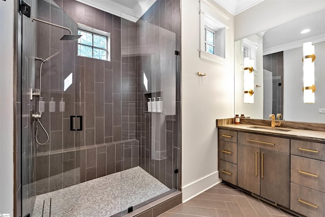 full bathroom with ornamental molding, a stall shower, vanity, and baseboards