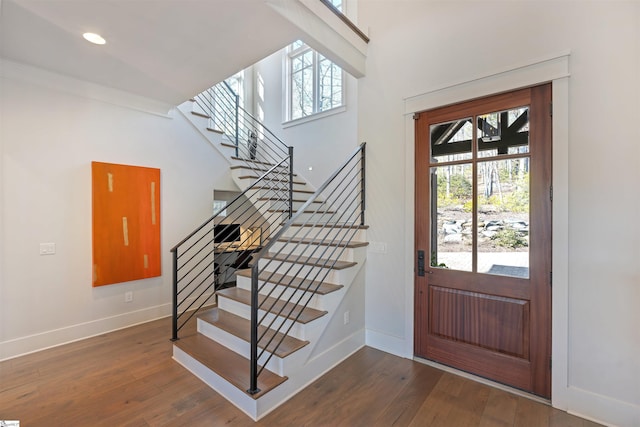 foyer entrance featuring recessed lighting, wood finished floors, baseboards, stairs, and ornamental molding