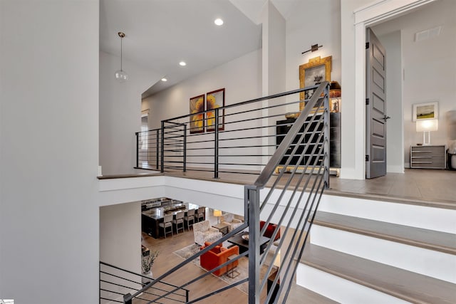 stairway featuring recessed lighting, visible vents, baseboards, and wood finished floors