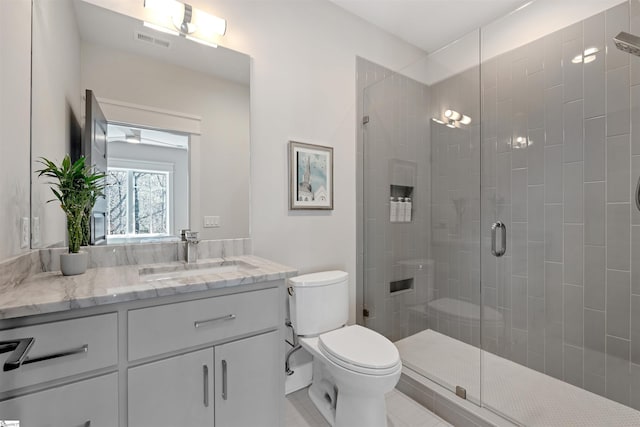 bathroom featuring visible vents, vanity, a shower stall, and toilet