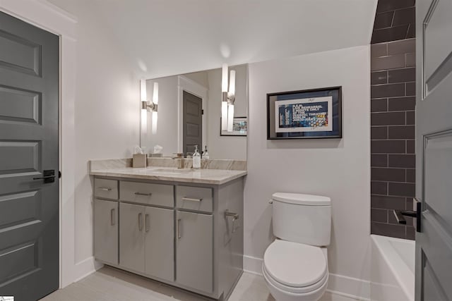 bathroom featuring vanity, toilet, and baseboards