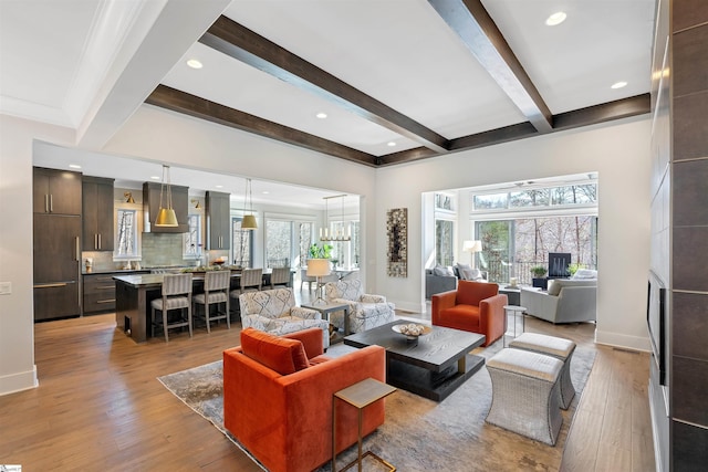 living area featuring recessed lighting, baseboards, beamed ceiling, and light wood finished floors