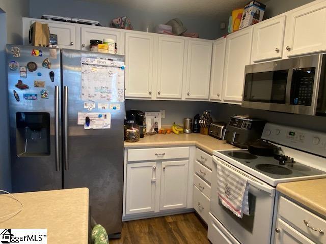 kitchen featuring stainless steel appliances, light countertops, dark wood-style floors, and white cabinetry