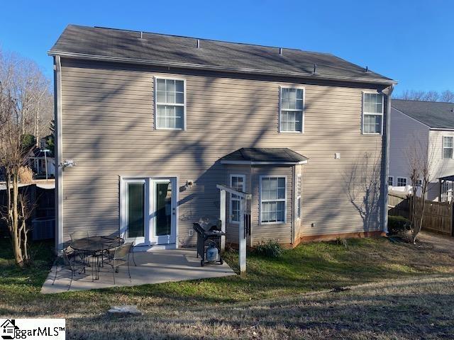 back of property with a patio, fence, and a lawn