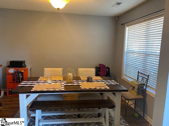 dining room featuring wood finished floors, visible vents, and baseboards