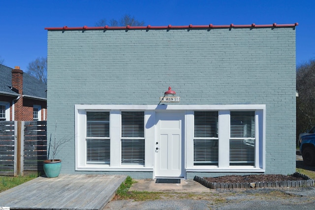 view of front of property with brick siding and fence