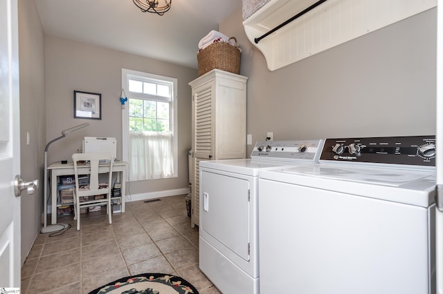 laundry area with laundry area, baseboards, washing machine and clothes dryer, and light tile patterned floors