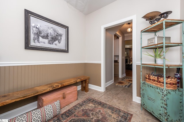 corridor with tile patterned flooring and wainscoting