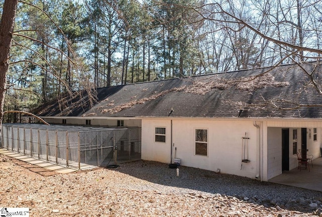 back of property featuring a shingled roof and a patio area