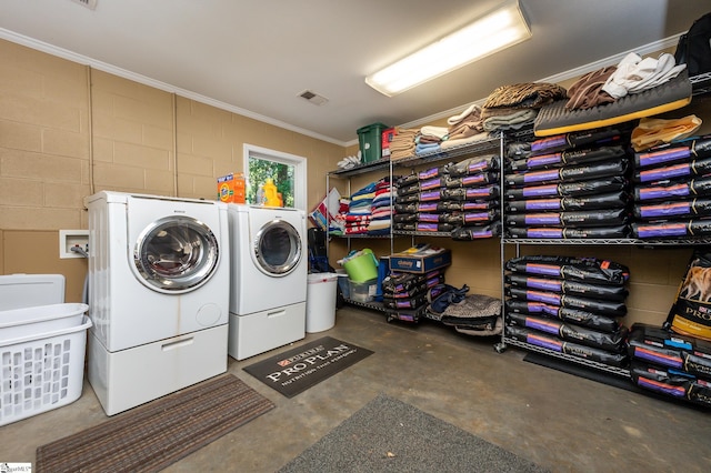 laundry area featuring concrete block wall, laundry area, visible vents, ornamental molding, and independent washer and dryer