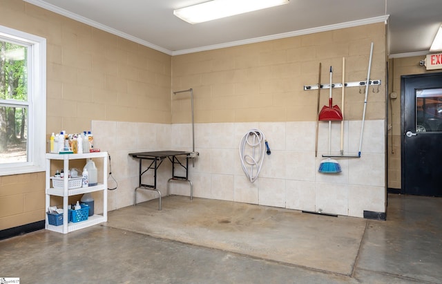 misc room featuring ornamental molding, concrete floors, and concrete block wall