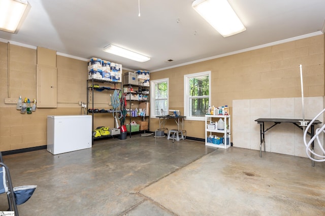 garage with concrete block wall and fridge