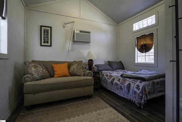 bedroom featuring a wall unit AC, wood finished floors, and lofted ceiling