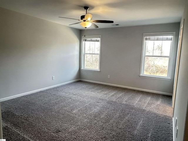 carpeted spare room with ceiling fan, visible vents, and baseboards