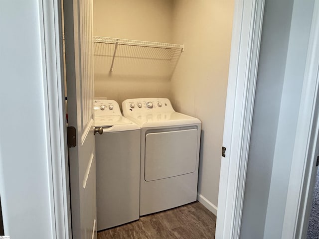 laundry area with laundry area, separate washer and dryer, and dark wood-type flooring