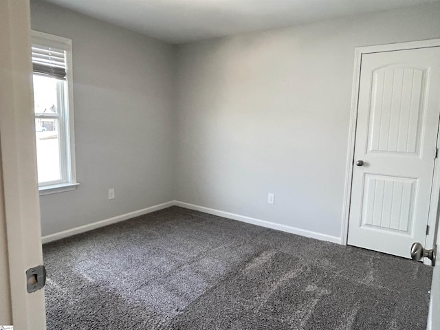 unfurnished room with baseboards and carpet flooring