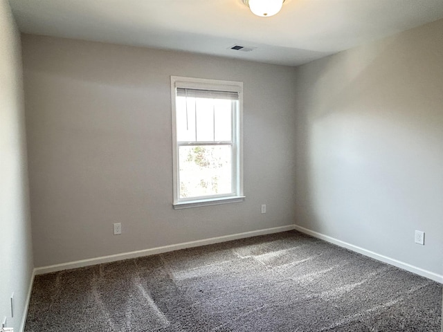 empty room featuring carpet, visible vents, and baseboards