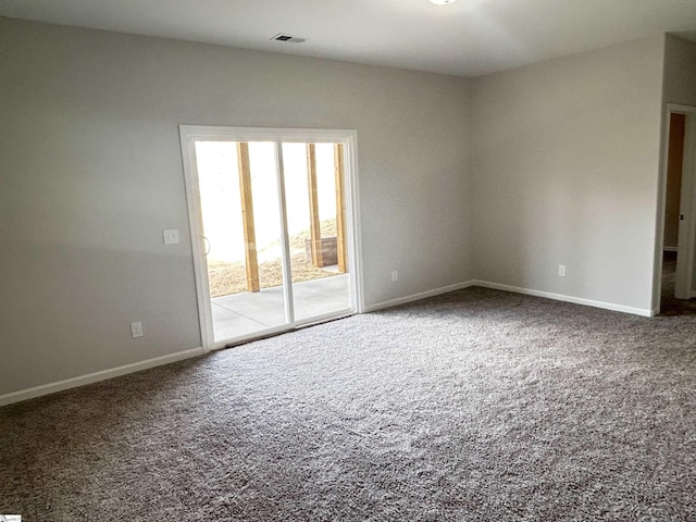 carpeted empty room featuring visible vents and baseboards