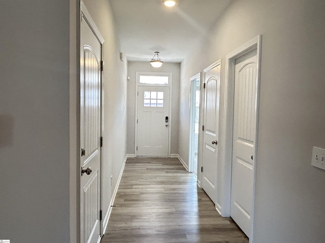 doorway featuring wood finished floors and baseboards