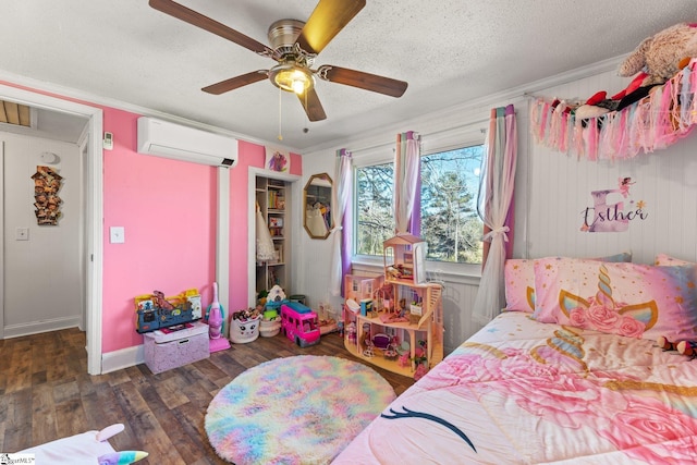 bedroom featuring a ceiling fan, ornamental molding, wood finished floors, a textured ceiling, and an AC wall unit