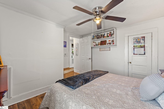 bedroom featuring ornamental molding, wood finished floors, a ceiling fan, and baseboards