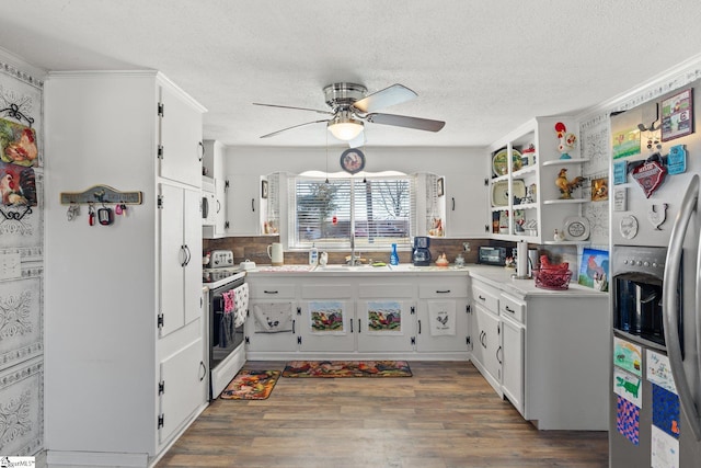 kitchen featuring dark wood-style flooring, range with electric stovetop, light countertops, a sink, and stainless steel fridge