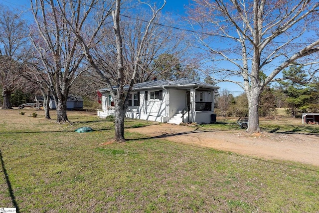 view of front facade with driveway, a front lawn, and brick siding