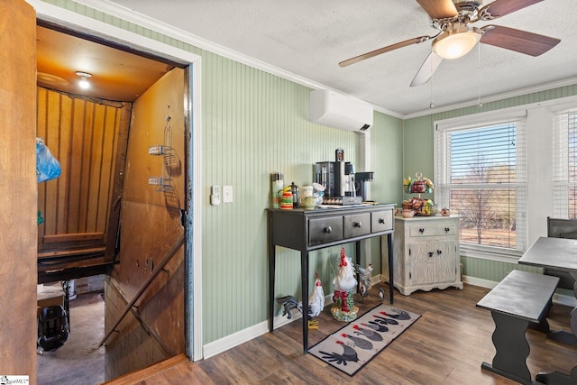 office featuring a wall unit AC, a textured ceiling, ornamental molding, and wood finished floors