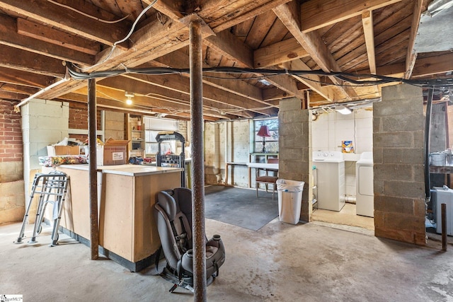 unfinished below grade area featuring concrete block wall and washer and clothes dryer