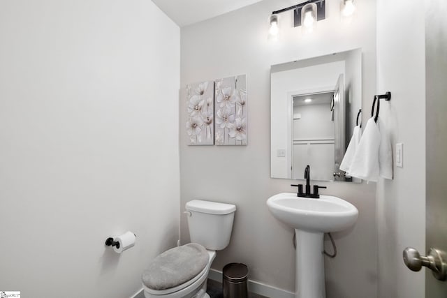 bathroom featuring toilet and baseboards