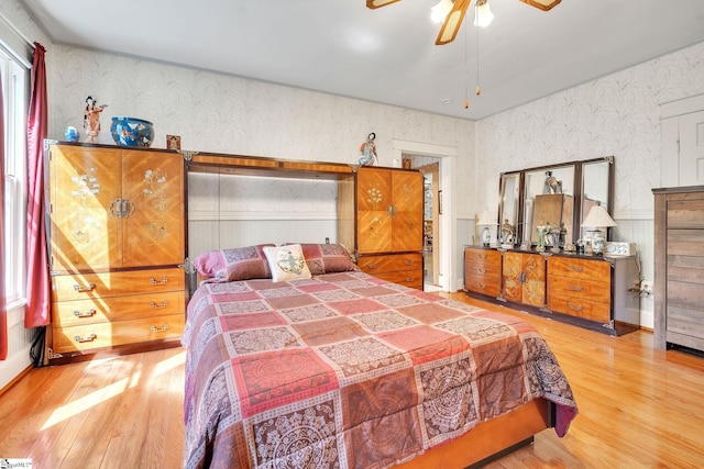 bedroom with wood finished floors and wallpapered walls