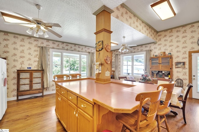 kitchen with wallpapered walls, light wood-style flooring, and baseboards