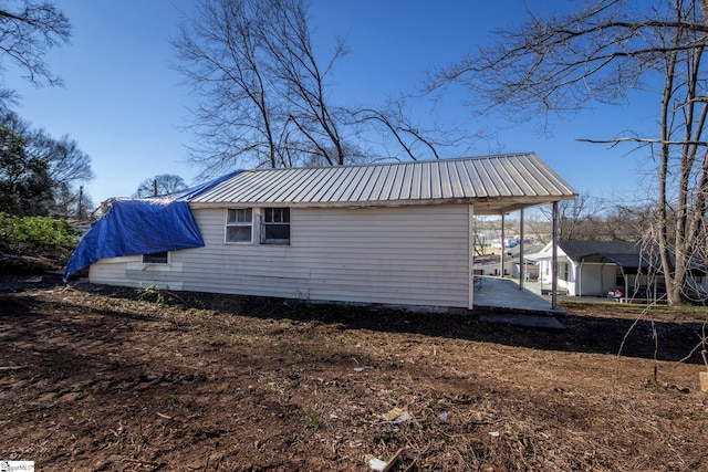 view of side of property with metal roof and a carport