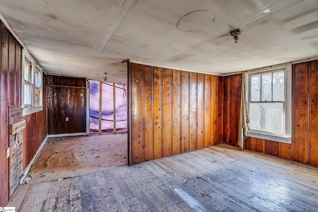 spare room with wood walls and wood-type flooring