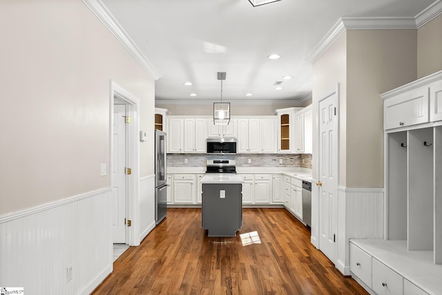 kitchen with appliances with stainless steel finishes, wainscoting, and white cabinetry