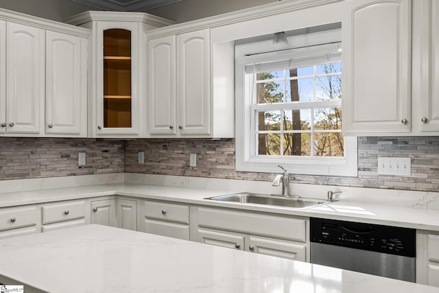 kitchen with stainless steel dishwasher, a sink, and white cabinets